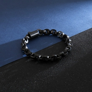 Détail macro du bracelet gourmette en acier noir mat avec fermoir cylindrique à fiche