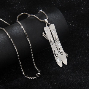 Polished silver stainless steel ski pendant necklace on black display stand