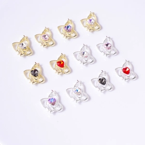 Detailed close-up of heart-shaped nail charms with star rings and colorful crystals