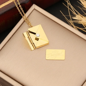 Golden envelope locket necklace with I love you card on a minimalist jewelry box