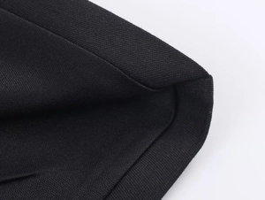 Detaillierte Nahaufnahme der Wabenstrickstruktur des schwarzen Jumpsuit-Stoffes