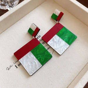 Detail view of geometric acrylic drop earrings featuring red, green and marble white resin