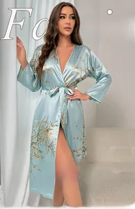 Detail of light blue silk robe with elegant floral patterns and waist tie