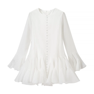Detail of white long sleeve dress showing button row and textured fabric finish
