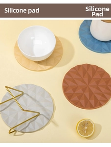 Detailed top view of geometric embossed silicone pads in four colors with gold metal stand