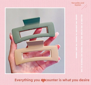 Detail of matte rectangular hollow hair claw clip in Morandi green and beige finish