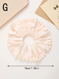 Détail d'un chouchou géant 18cm en satin crème avec des bords ondulés élégants