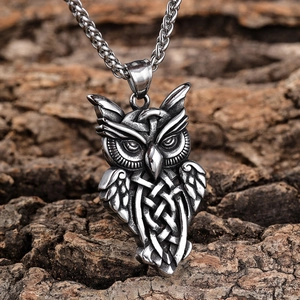 Close-up of vintage owl pendant with Celtic knots against natural wood bark background