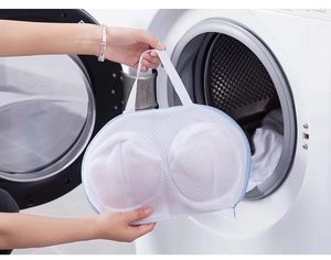 Detailed mesh laundry bag for bras showing thickened fabric and blue zipper in a washing machine