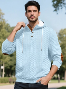 Détail du sweat à capuche bleu clair montrant la maille losange et les coudières brunes