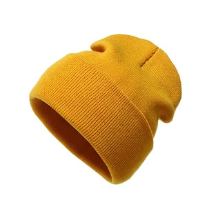 Detailed close-up of yellow knit beanie featuring a classic ribbed texture and folded cuff