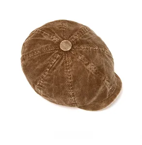 Detailed top view of brown corduroy newsboy cap showing texture and center button