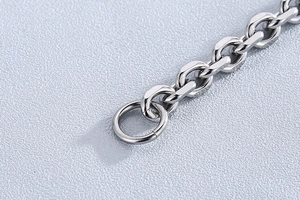 Macro shot of silver stainless steel O-chain link and OT clasp details on a textured surface