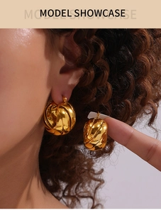 Detail shot of a model wearing a twisted gold spiral earring with a polished finish