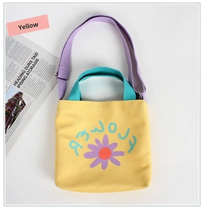Detail of yellow canvas tote bag with purple daisy print and contrast shoulder straps