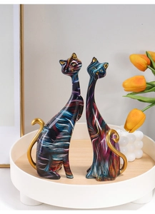 Close-up of abstract colorful feline statues with golden accents and fluid art pattern