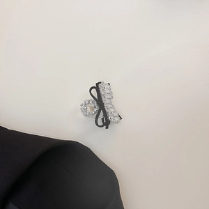 Close-up of a silver rhinestone hair claw clip with a black ribbon bow detail