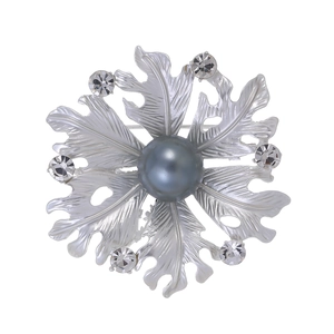 Macro shot of silver flower brooch with matte pearl and sparkling crystal accents