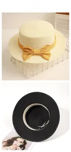 Detail view of woven straw boater hat with adjustable ribbon and yellow bow accent