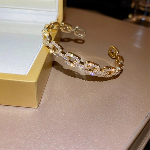 Close-up of gold plated chain link bracelet with pave cubic zirconia on a jewelry box