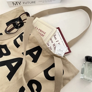 Detailed view of beige canvas tote bag interior with books showing large capacity