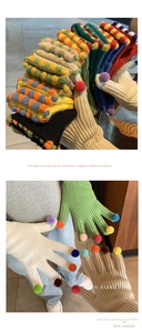 Dettaglio dei guanti in maglia con pompon di peluche colorati sulle dita e sul dorso
