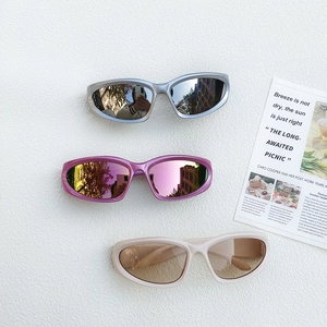 Three colors of kids sports sunglasses in silver, purple, and beige on textured background