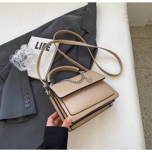 Detail showing khaki PU leather handbag with silver chain and elegant top handle