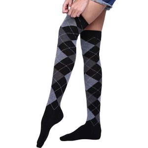 Detail of knitted over-the-knee socks featuring classic black and white diamond patterns