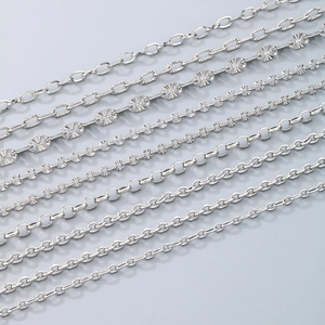 Minimalist silver chain anklets in various link styles and thicknesses on gray background