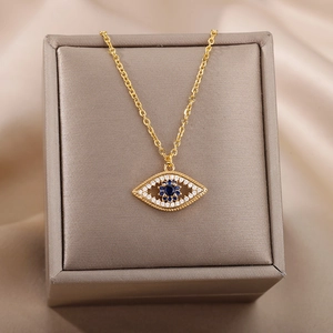 18k gold-plated Evil Eye necklace with blue zircon pendant on beige silk surface