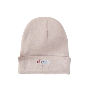 Close-up of pink knitted beanie with colorful dream word and star embroidery details