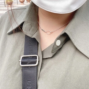Close-up of a s925 silver geometric olive bead necklace worn on a female neck