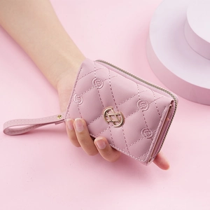 Women's pink quilted tri-fold wallet with gold logo hardware and zipper detail