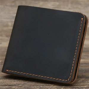 Detail view of carbon black crazy horse leather wallet with vintage orange contrast stitching