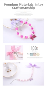 Detailed view of pearl pet necklace featuring bow ribbon and rhinestone bone pendant