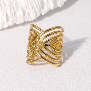 Retro hollow geometric wide gold plated stainless steel ring on white texture
