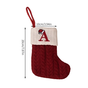 Detail of red cable knit Christmas stocking with embroidered white letter A and 20cm height