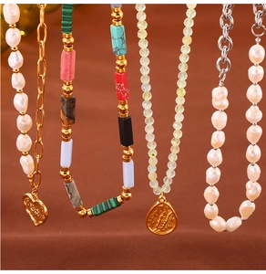 Detailed shot of handmade natural stone beaded necklaces with gold pendants and pearls