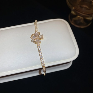 Macro view of gold-tone flower bracelet with heart-cut cubic zirconia and pave setting
