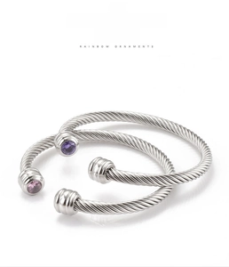 Detailed shot of silver twisted wire bangles with purple and pink zircon stones