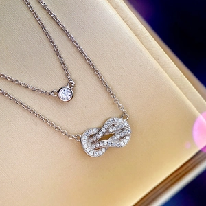 Makroaufnahme von glitzerndem Knotenhänger und Solitär-Diamantkette aus Silber