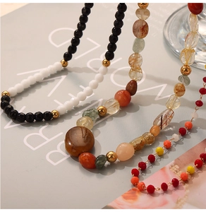 Detail of beaded gold plated necklace featuring natural agate stones and irregular pearls