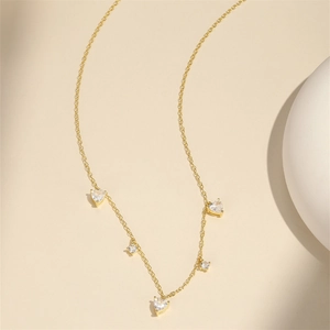 Detail of s925 silver gold necklace featuring heart and round zircon pendants