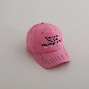 Close-up of pink cotton baseball cap with black embroidered text and stitched brim