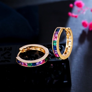 Close-up of golden hoop earrings featuring colorful square-cut rainbow zircon stones