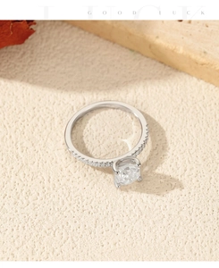 Close-up of sparkling 1 carat moissanite silver ring with pavé diamonds and warm lighting