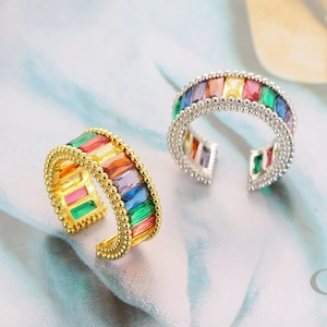 Macro shot of gold and silver open rings with colorful rectangle-cut zircon stones