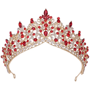 Close-up of golden bridal tiara featuring intricate filigree with ruby red crystals
