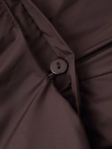 Detailed macro view of smooth dark brown fabric with a matching round button closure